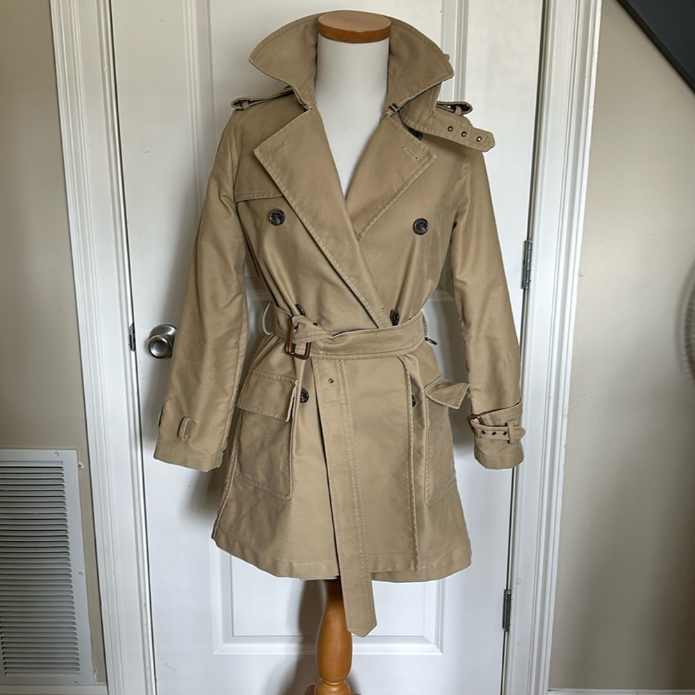 Designed with a classic double-breasted silhouette and a belted waist,